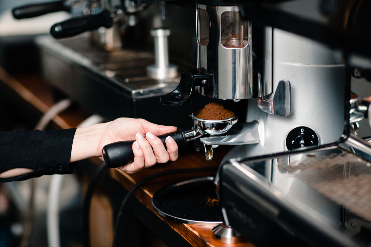 Barista melakukan setting grinder Maquinos