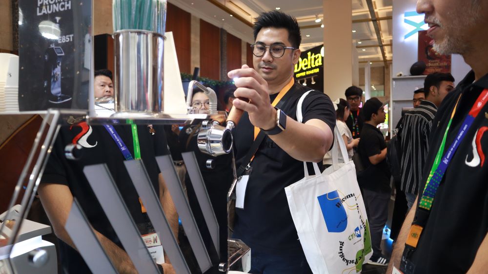Pengunjung mencoba mesin kopi Hambach di booth Scuro dan mencicipi minuman Denali di SIAL InterFOOD 2025.