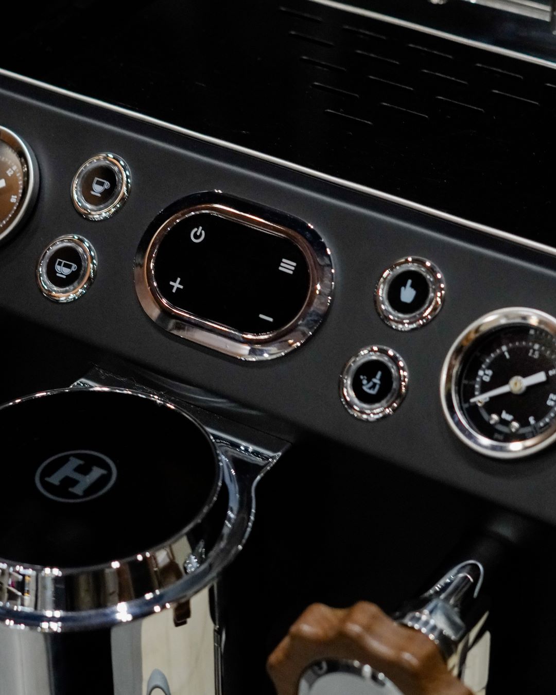 Barista menuang susu menggunakan steam wand Mesin Hambach, memperlihatkan crema espresso di cangkir.