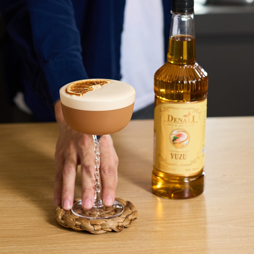 Minuman Fully Passiontea dengan warna cerah dan foam lembut, memadukan passion fruit, yuzu, rose, black tea, dan lemon.