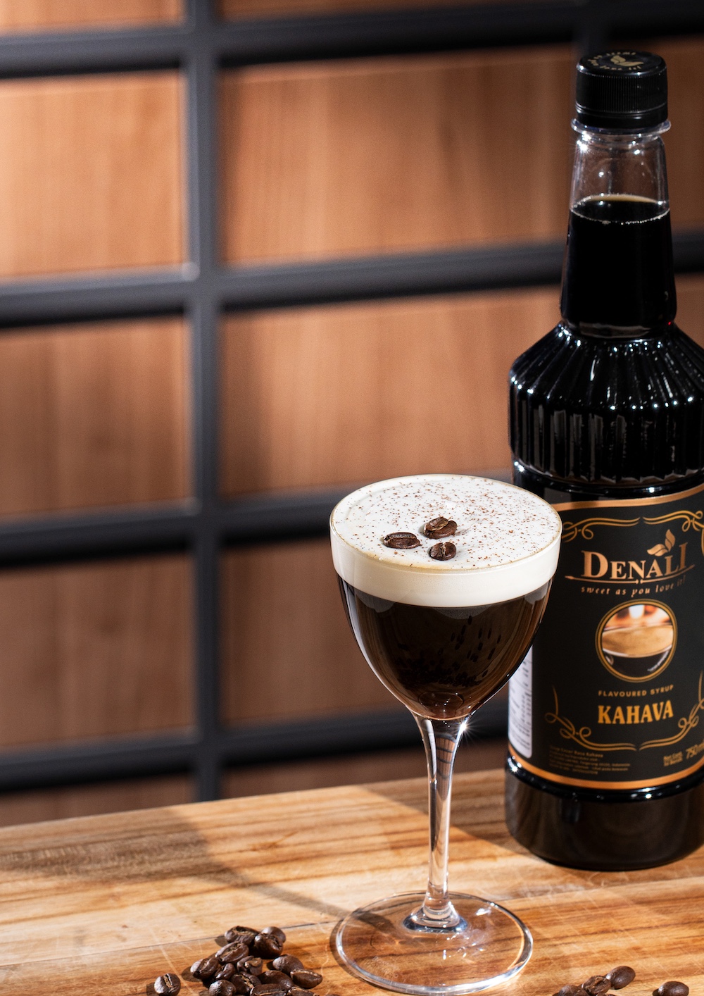 Kahava Coffee Cream menggunakan Denali Kahava Syrup dan Honey Syrup dengan topping whipped cream, cinnamon dusting, dan coffee beans dalam gelas Nick & Nora.