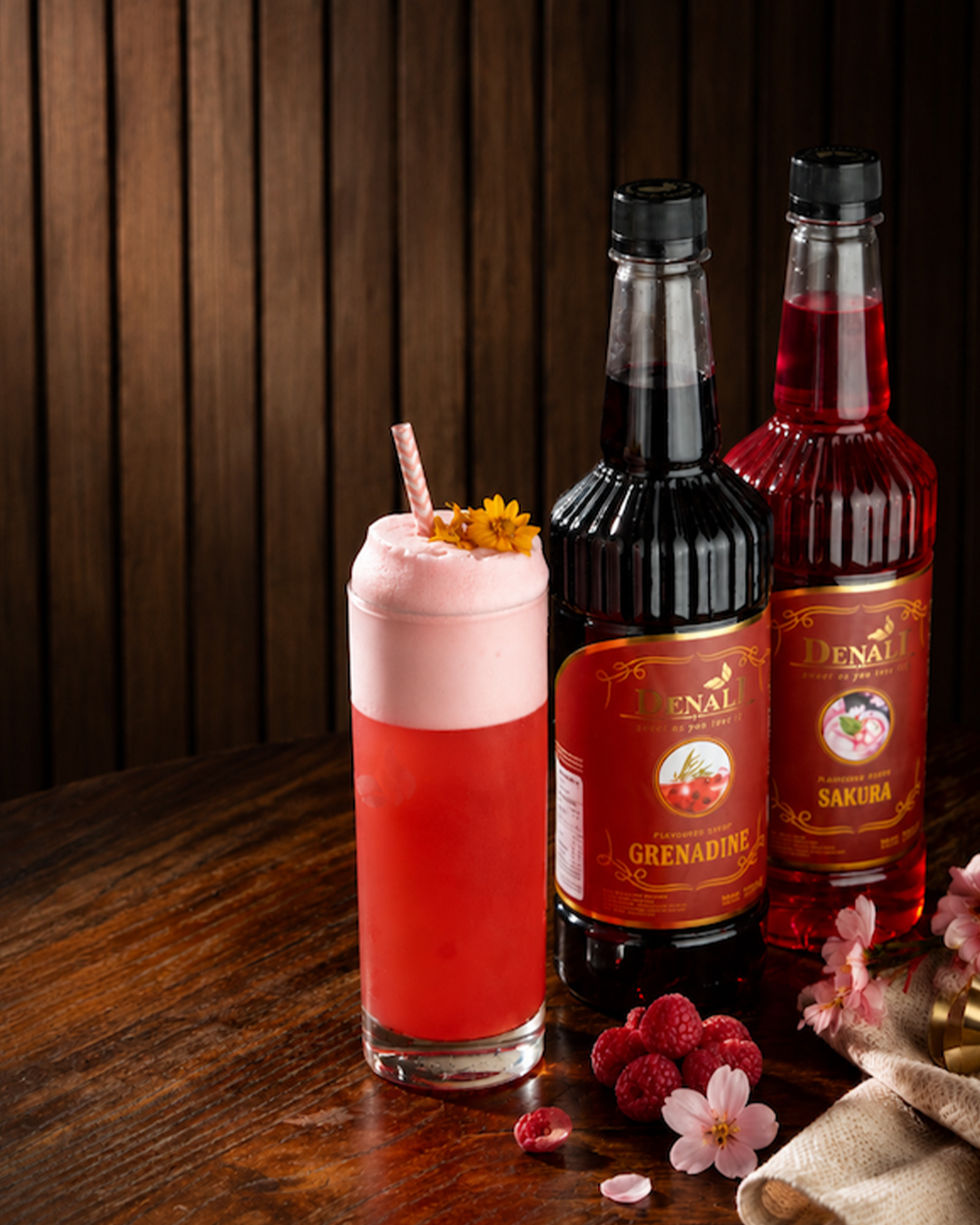 Elegant Summer Sour, mocktail floral dengan garnish straw gold dan bunga merah di high ball glass